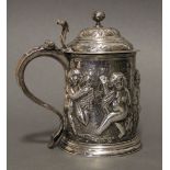 A GEORGE I SILVER LIDDED TANKARD of slightly tapered cylindrical form, the body with repoussé