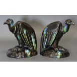 A pair of French Art Deco pottery book-ends modelled as vultures perching on a rock, with blue &