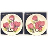 A pair of modern Moorcroft “Magnolia” pattern 10” diam. plates of cream ground; with boxes.