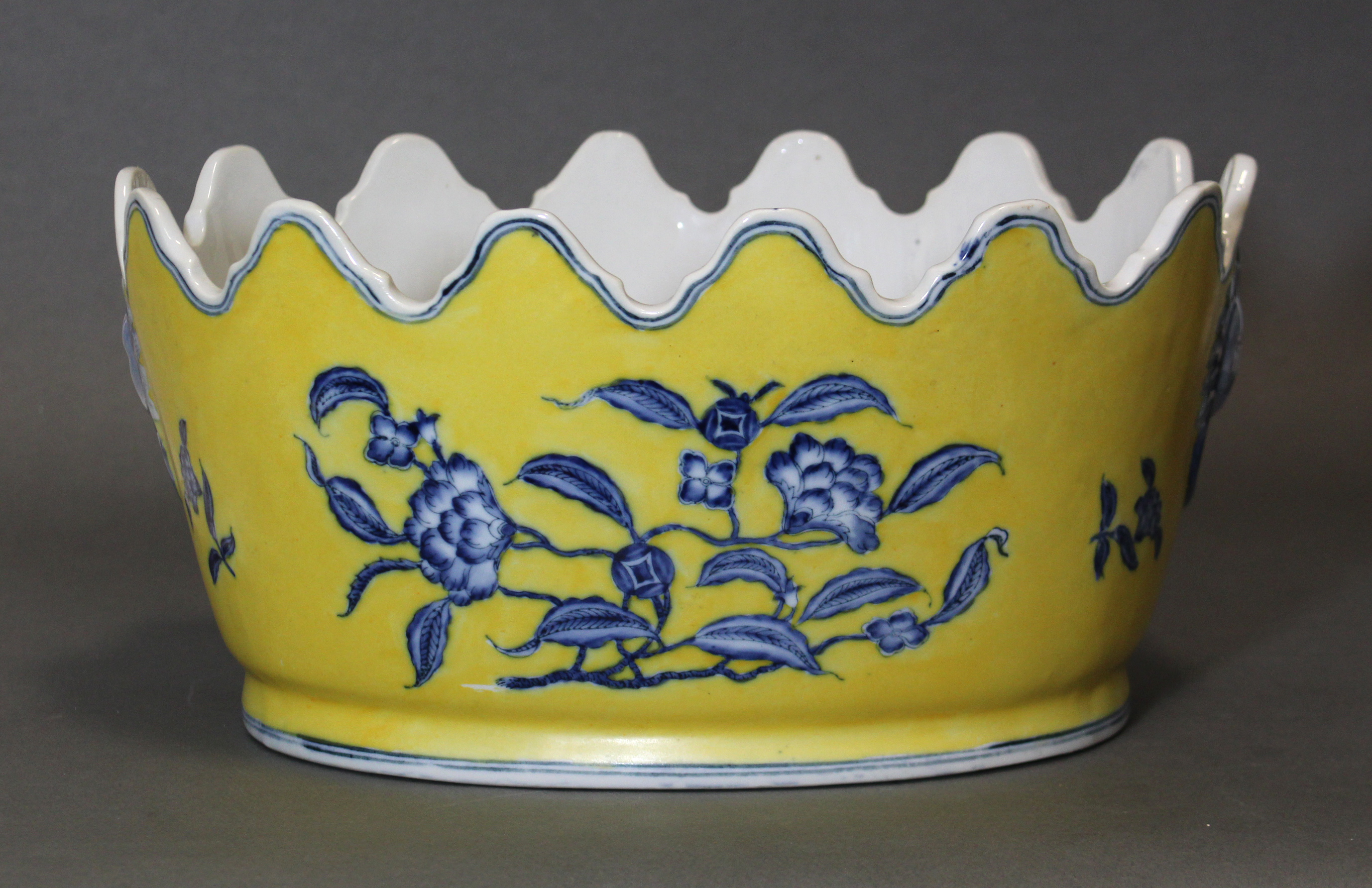 A Chinese porcelain oval jardinière of monteith shape, with underglaze blue decoration on a yellow