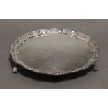 A late Victorian silver salver with shaped gadrooned rim & narrow foliate border, on three claw-&-