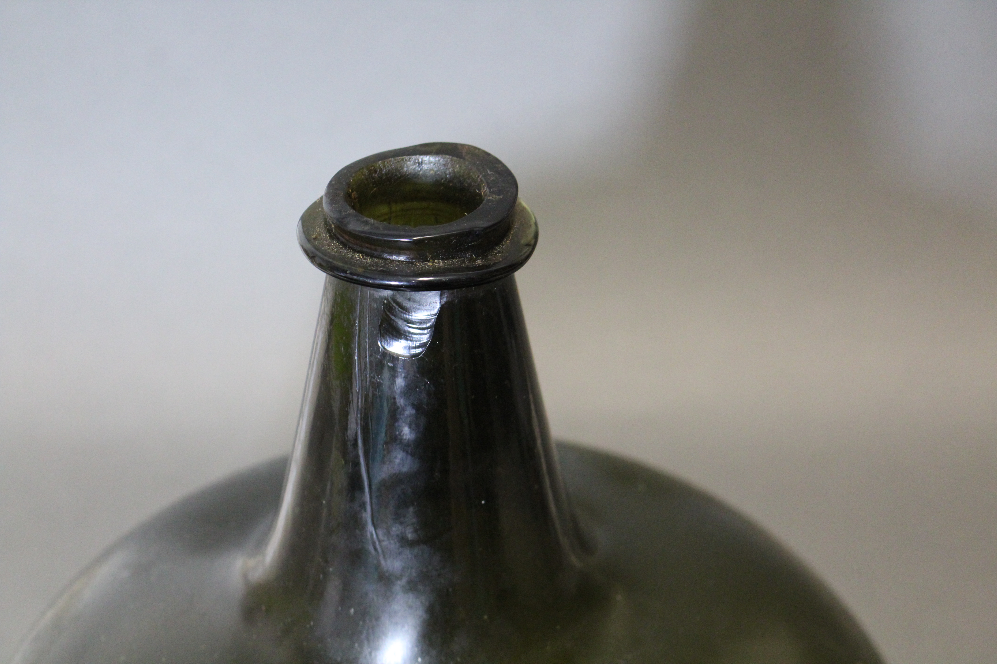 An 18th century green glass wine bottle of squat “onion” form, with tapered neck, 10¾” high. (slight - Image 5 of 6