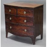 A George III mahogany bow-front chest fitted three graduated drawers with brass ring handles, on