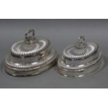 A pair of Old Sheffield plated graduated oval dish covers of semi-fluted domed shape, with gadrooned