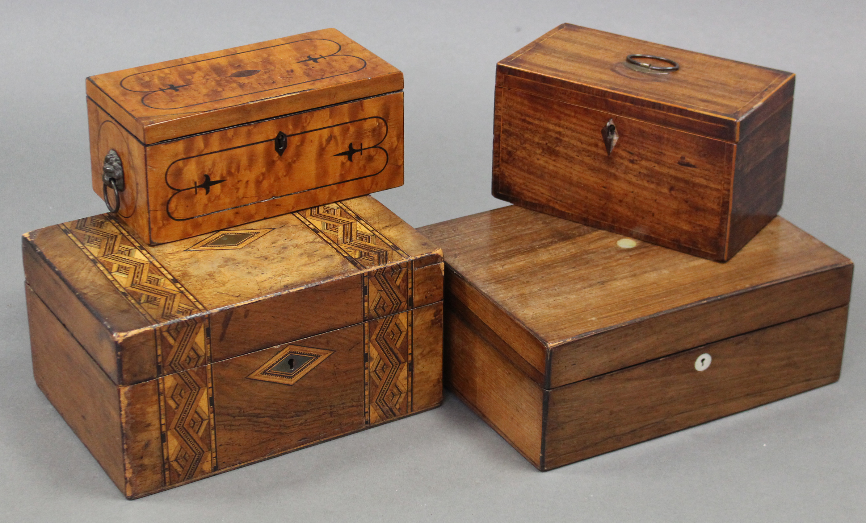 A Regency satinwood two division tea caddy with ebonised string inlay & lion-mask & ring side