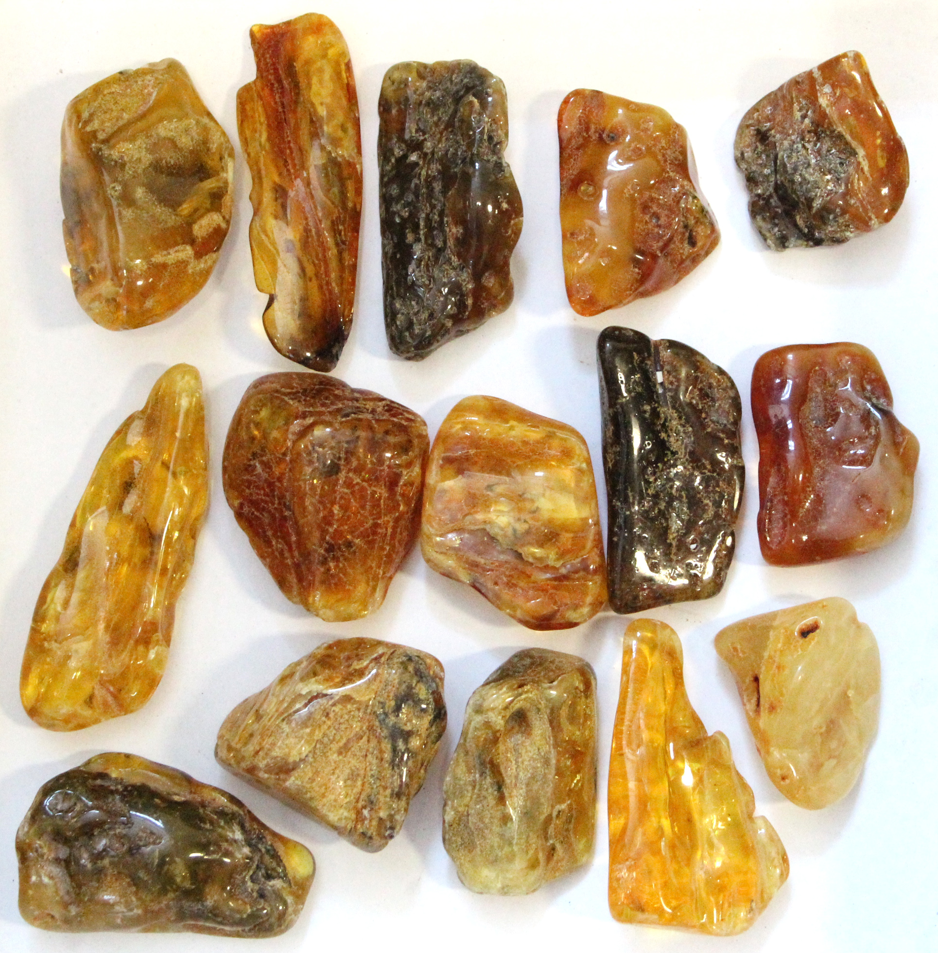 Fifteen natural amber “nuggets”, each of irregular shape, & varying in tone & opacity.