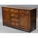 AN 18th century OAK DRESSER BASE, fitted six drawers with brass swan-neck handles, a cupboard either
