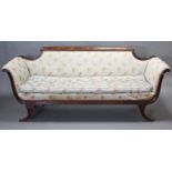 A Regency style carved mahogany-frame sofa, with shaped back, reeded scroll arms & frieze, upholste