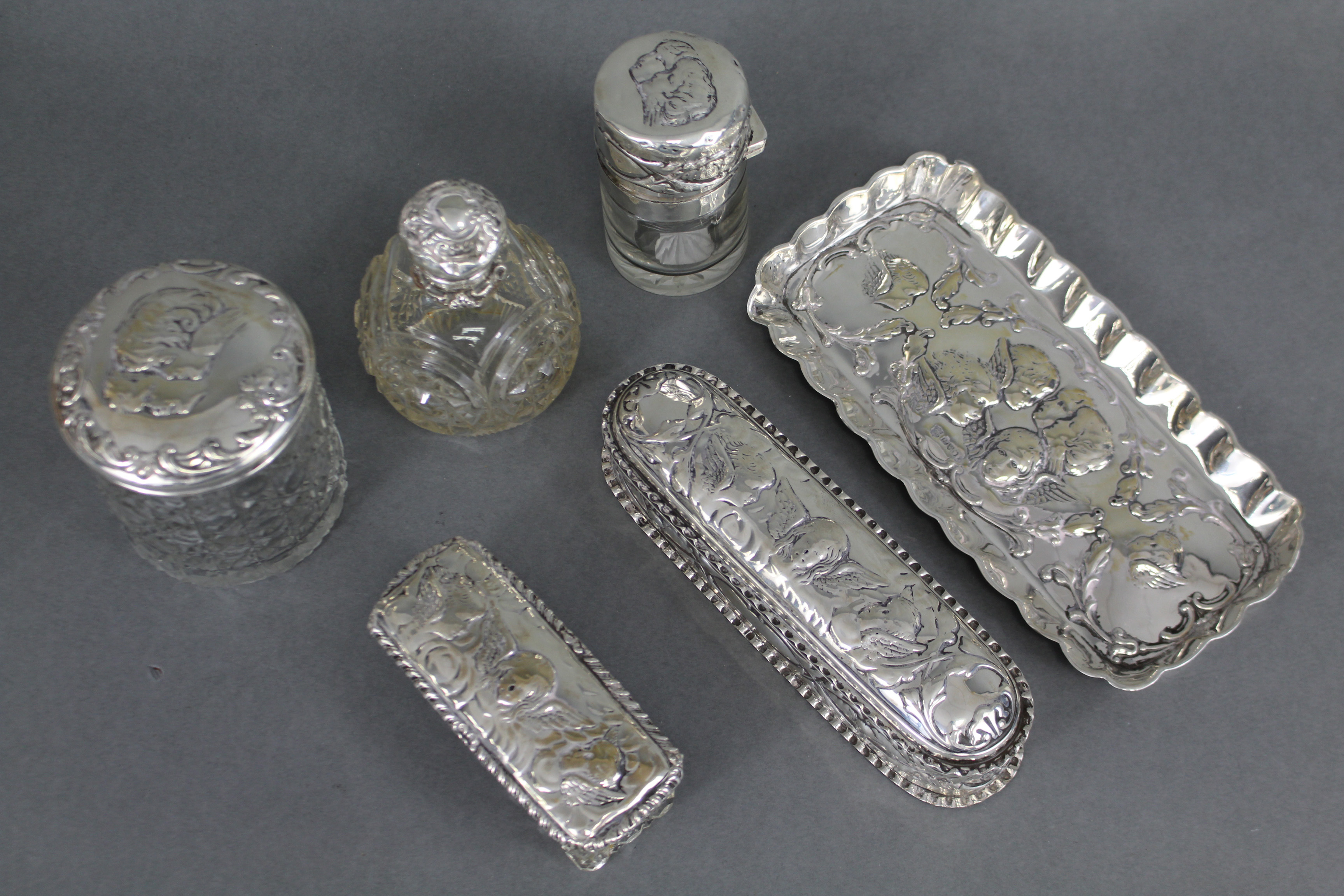 An Edwardian silver toilet set embossed with cherub masks, comprising: a rectangular pin tray, 7¾” x - Image 2 of 2
