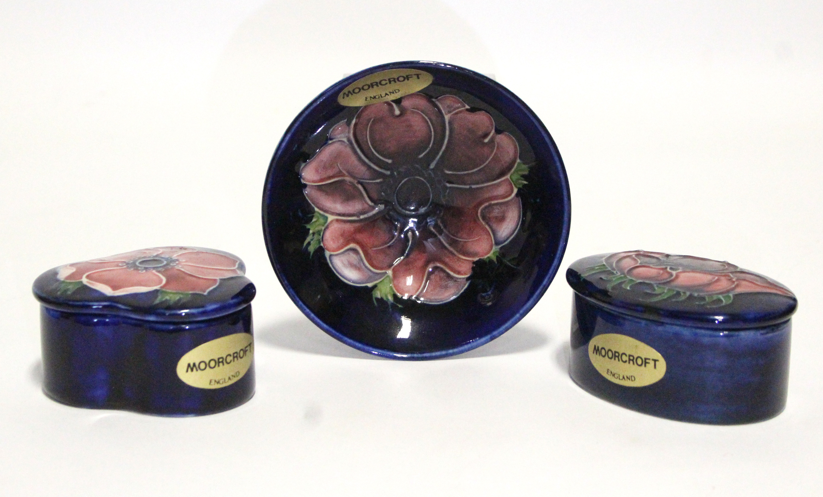 A Moorcroft “Anemone” small trefoil-shaped box & cover, 2¾” wide; an oval ditto, 3”; & a ditto