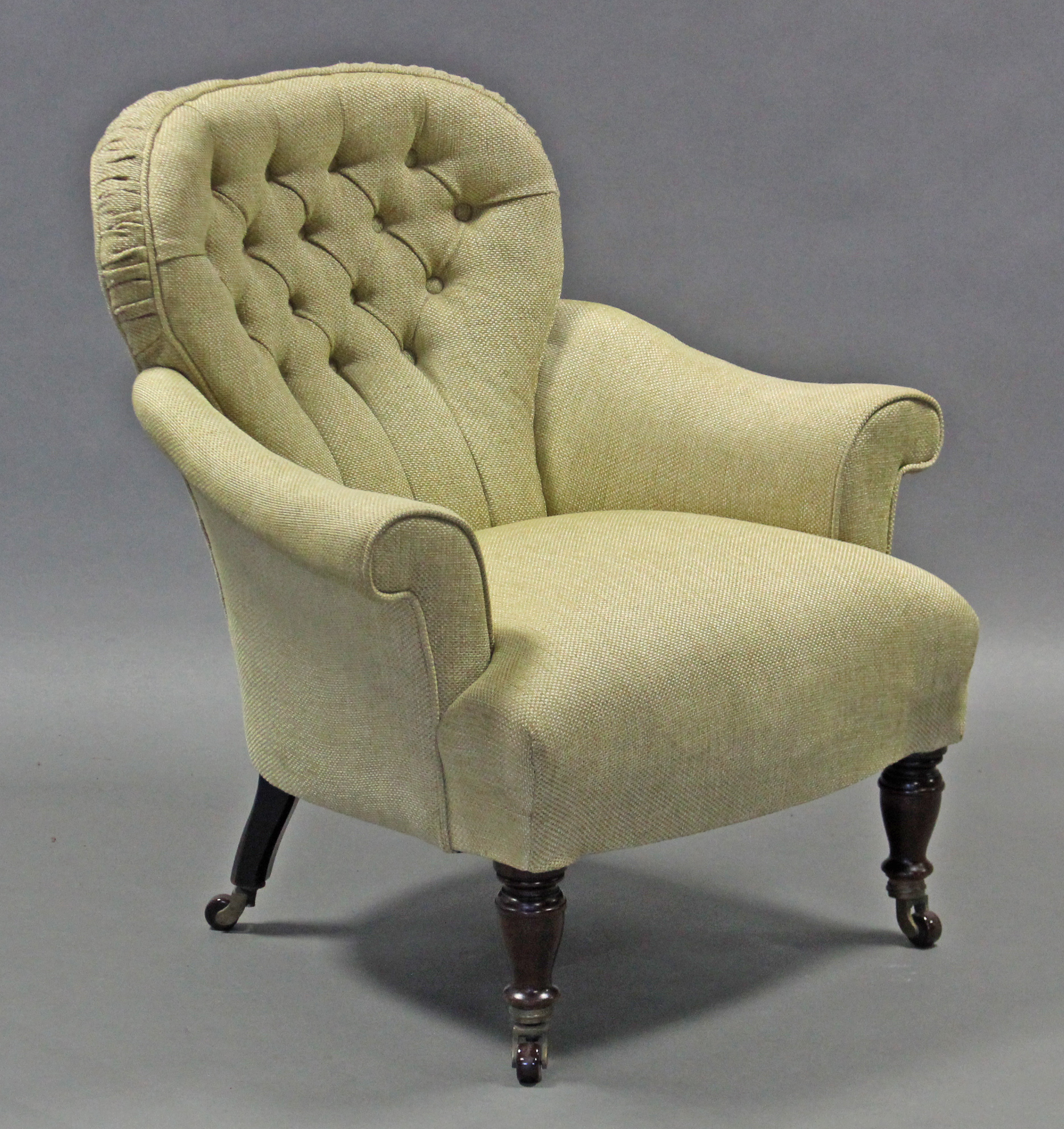 A Victorian armchair with rounded buttoned-back, scroll arms, & padded seat upholstered pale green