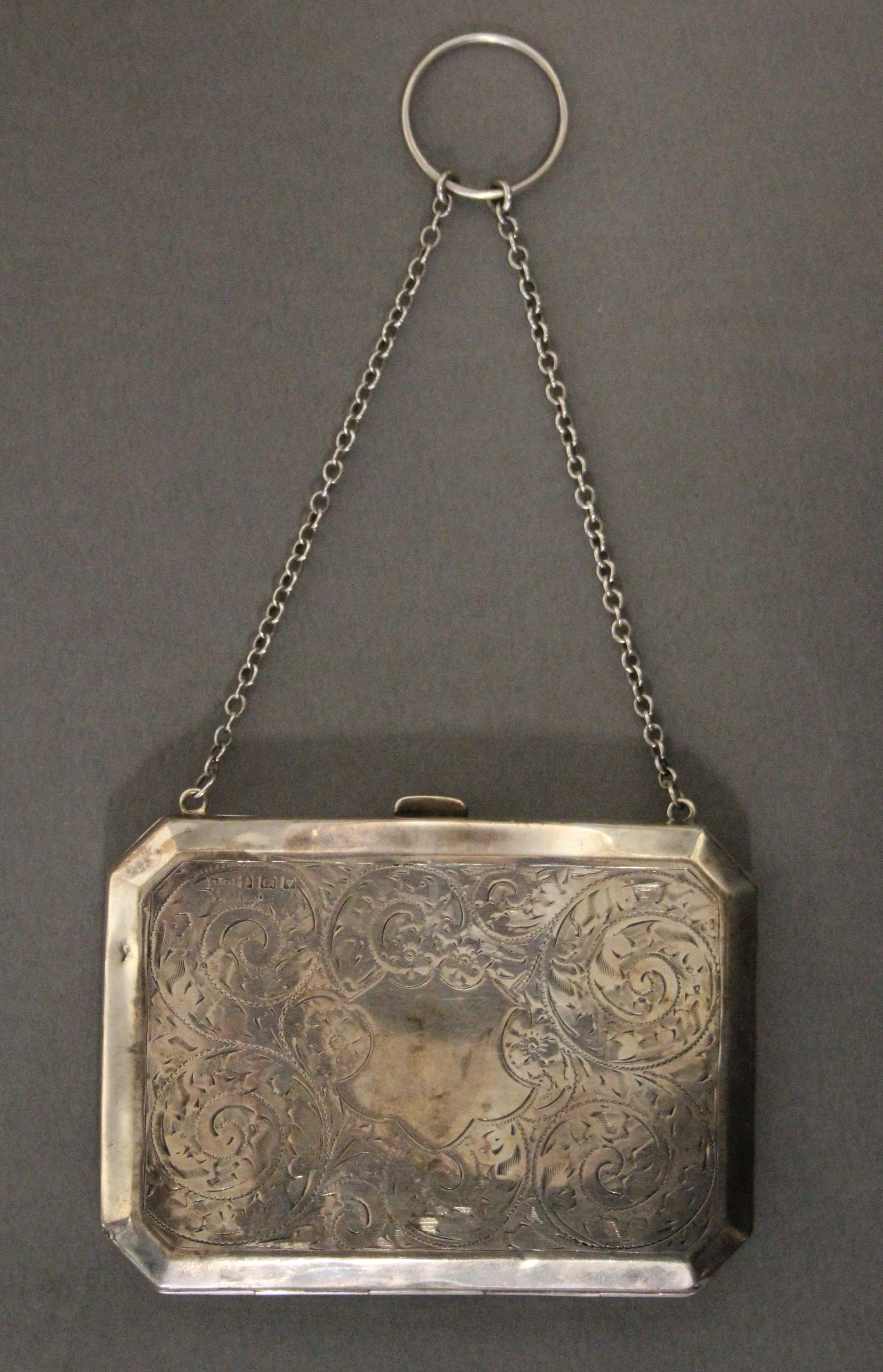 A George V engraved silver rectangular evening purse with canted corners, tan leather interior, &