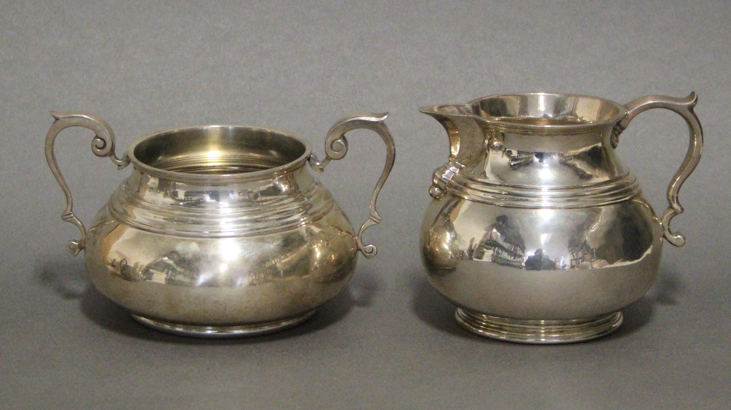 A George V heavy-gauge silver milk jug in the early 18th century style, of squat baluster form