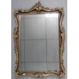 A 19th century rosewood & parcel-gilt leaf-scroll picture frame inset later mirror plate; 33½” x