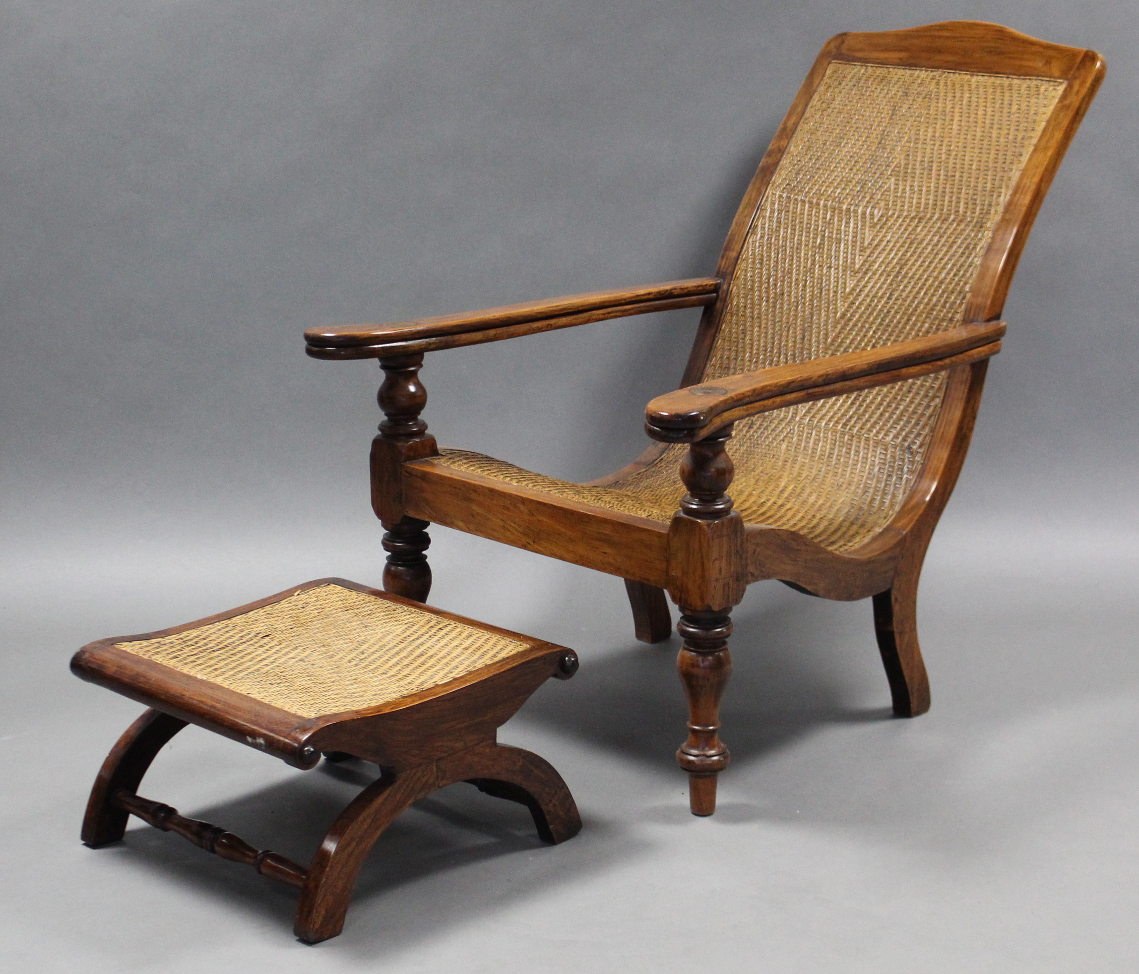 A 19th century rosewood plantation chair, with cane seat & back , curved open arms with fold-out