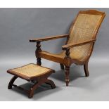 A 19th century rosewood plantation chair, with cane seat & back , curved open arms with fold-out