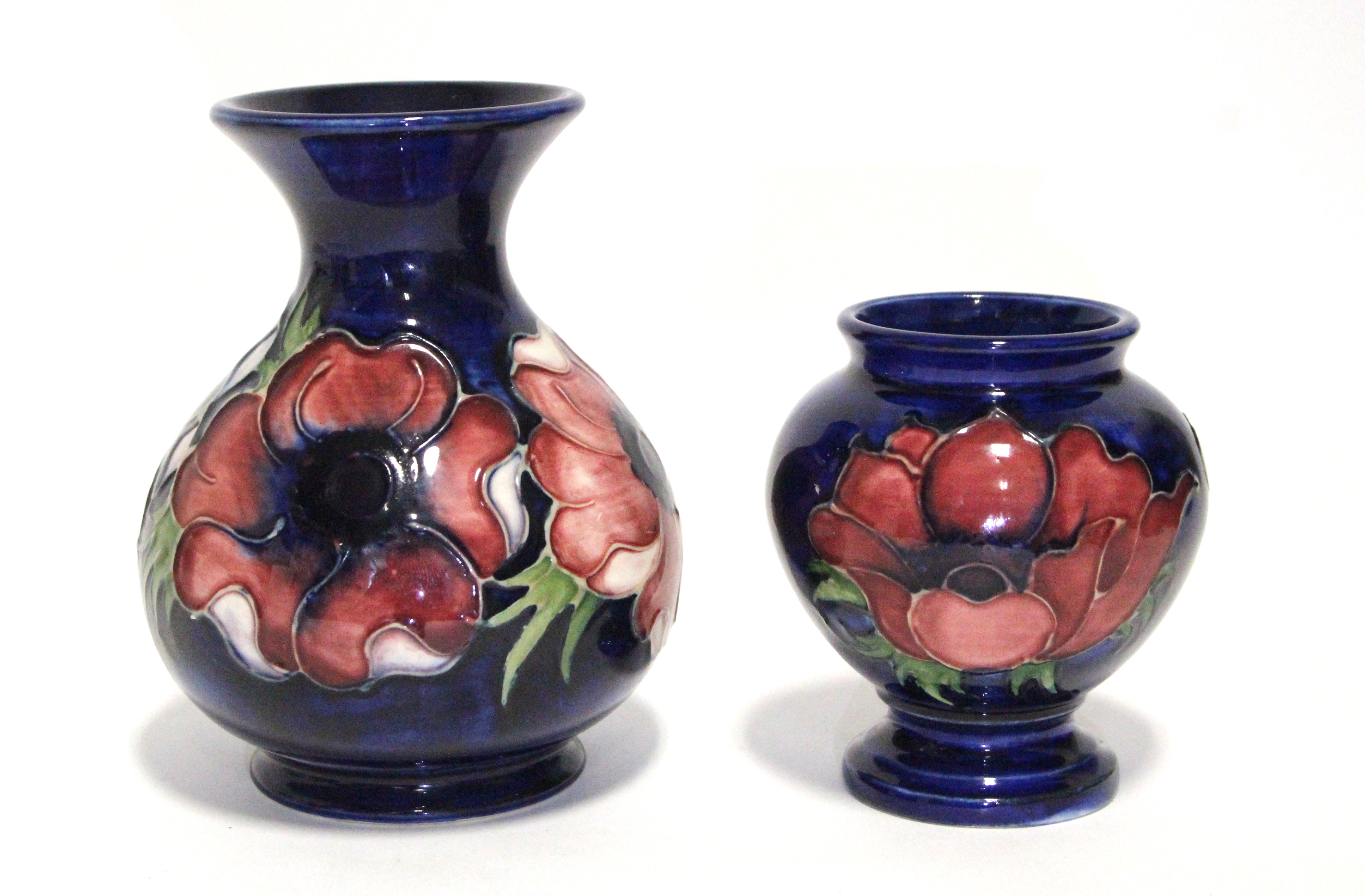 A modern Moorcroft “Anemone” squat round vase with trumpet neck, of dark blue ground, 5” high; & a