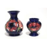 A modern Moorcroft “Anemone” squat round vase with trumpet neck, of dark blue ground, 5” high; & a
