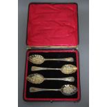 A set of four Edwardian silver-gilt ‘Berry’ spoons, the crimped oval bowls embossed with fruit;