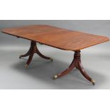 A Regency style mahogany twin-pedestal dining table with D-shaped ends, each on turned