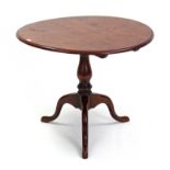 An oak pedestal dining table with circular top, & on vase-turned centre column & three cabriole