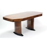 A mid-20th century burr-walnut extending dining table with canted corners to the rectangular top,