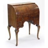 A burr-walnut cylinder-top desk with fitted interior enclosed by sliding front above four small