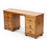 A pine knee-hole dressing table fitted with an arrangement of six long drawers, & on turned feet,