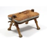 A camel stool, 25” wide; together with a display of John Player “Boy Scout & Girl Guide” cigarette