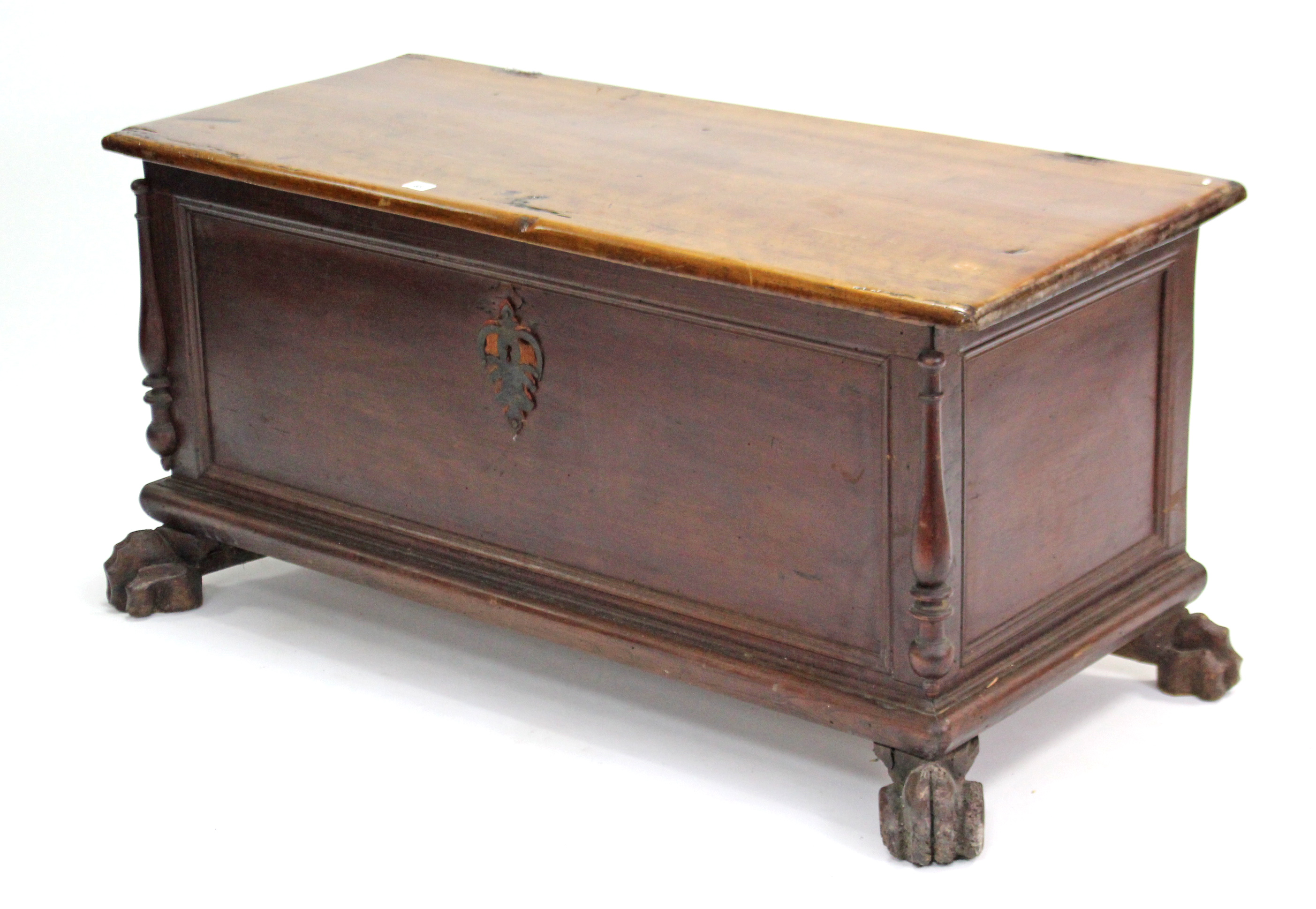 A 19th century continental hardwood coffer with hinged lift-lid, panelled front & sides, & on carved