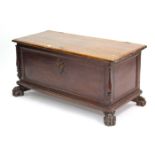 A 19th century continental hardwood coffer with hinged lift-lid, panelled front & sides, & on carved