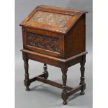 A 17th century style carved oak bureau of small proportions, the sloping fall-front enclosing