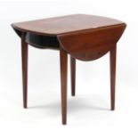 A reproduction mahogany oval Pembroke table on four square tapered legs, 33” wide.
