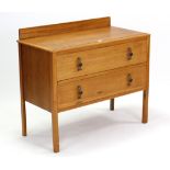 A light oak dwarf chest fitted two long drawers, & on short square legs, 34½” wide.