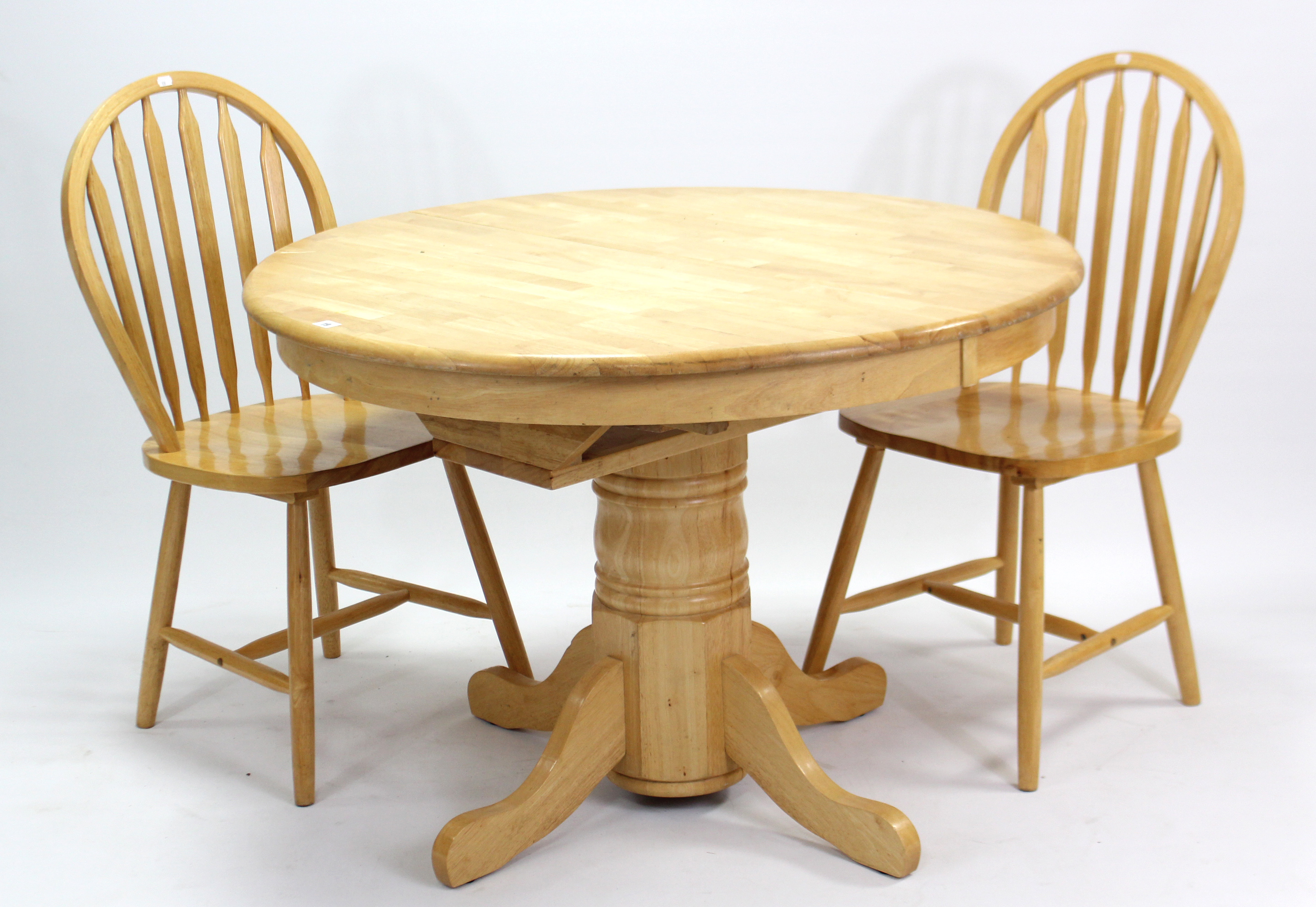 A maple-finish circular pedestal extending kitchen table with centre leaf; & on turned centre column