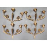 A set of four 19th century-style gold painted three branch wall sconces, with foliate scroll arms,