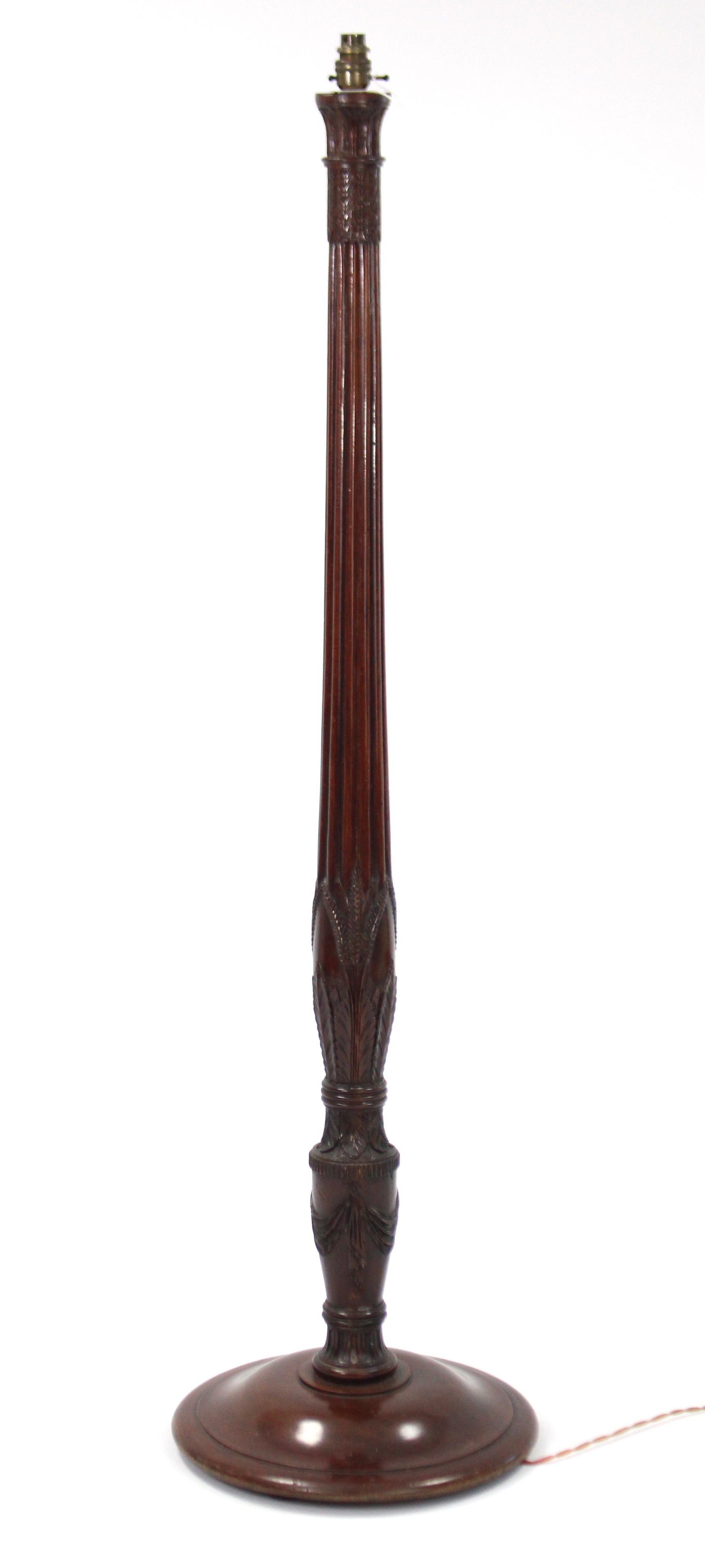 A carved mahogany standard lamp on circular base, complete with shade.