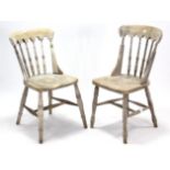 A pair of spindle-back kitchen chairs with hard seats, & on turned tapered legs with spindle