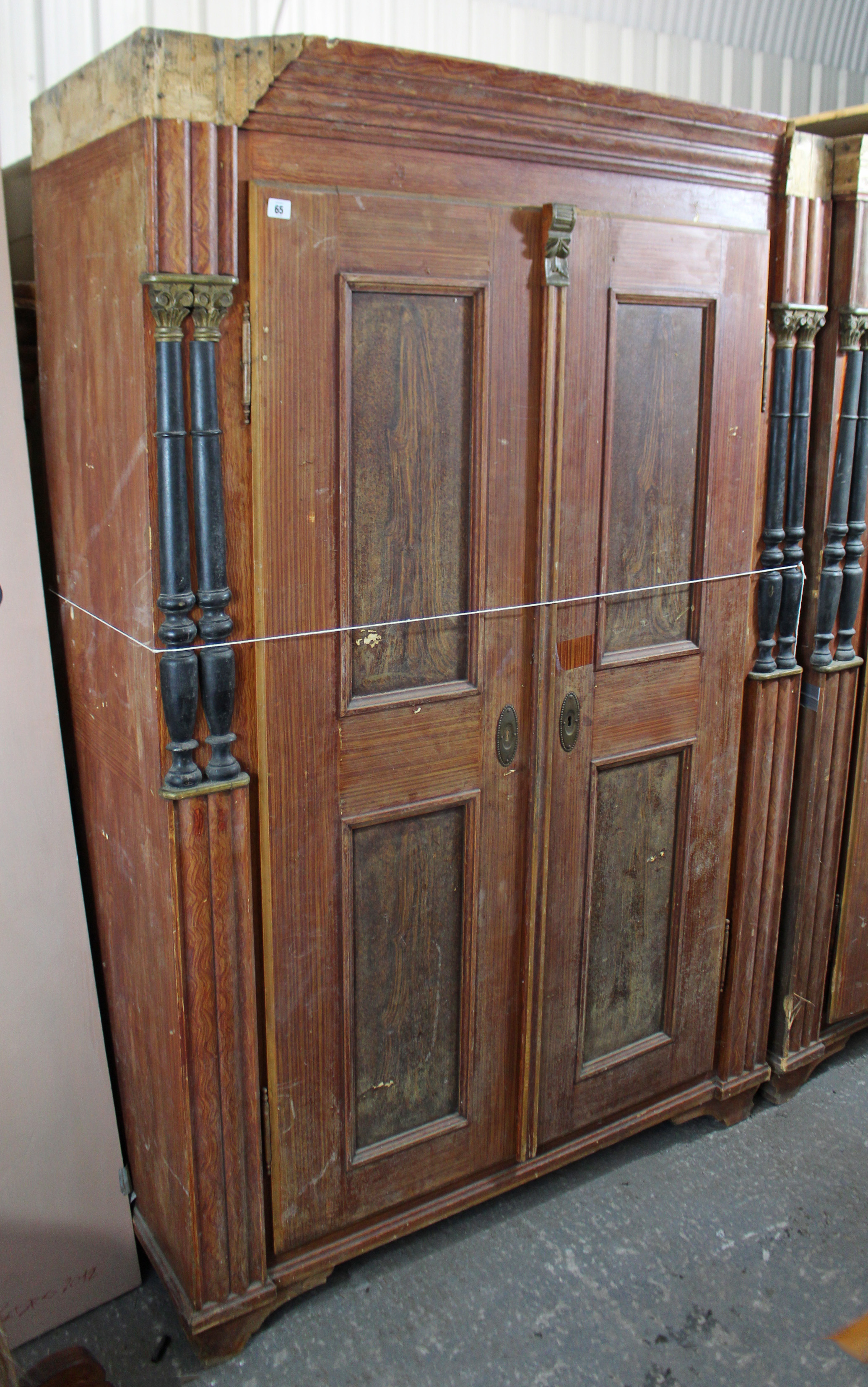 A continental-style grained pine wardrobe enclosed by pair of panel doors, with half turned