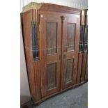 A continental-style grained pine wardrobe enclosed by pair of panel doors, with half turned