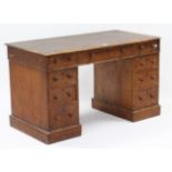 A Victorian oak pedestal desk inset crimson leather, & fitted with an arrangement of nine drawers,