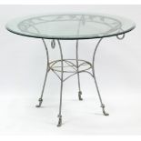 A silvered-metal patio table with pierced grape-vine border, on four slender legs, & with a bevelled