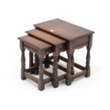 A reproduction oak nest of three rectangular occasional tables, each table on four baluster-turned