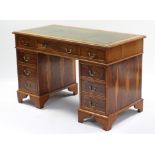A reproduction yew wood pedestal desk inset gilt-tooled green leather cloth, fitted with an