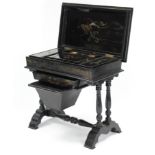 A Chinese style black Chinoiserie needlework table with fitted interior enclosed by hinged lift-