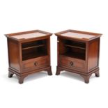 A pair of mahogany-finish bedside cabinets with revolving rectangular tray-tops, fitted open shelf