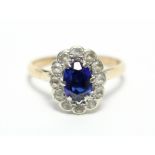 A 9ct gold ring set oval synthetic sapphire within a border of small diamonds.