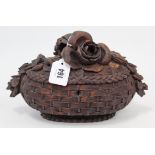 A Black Forest-type carved wooden oval trinket box in the form of a basket with flowers to the