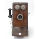 A mid-20th century Western Electric (American) oak-cased wall mounted telephone, 20¼” high.