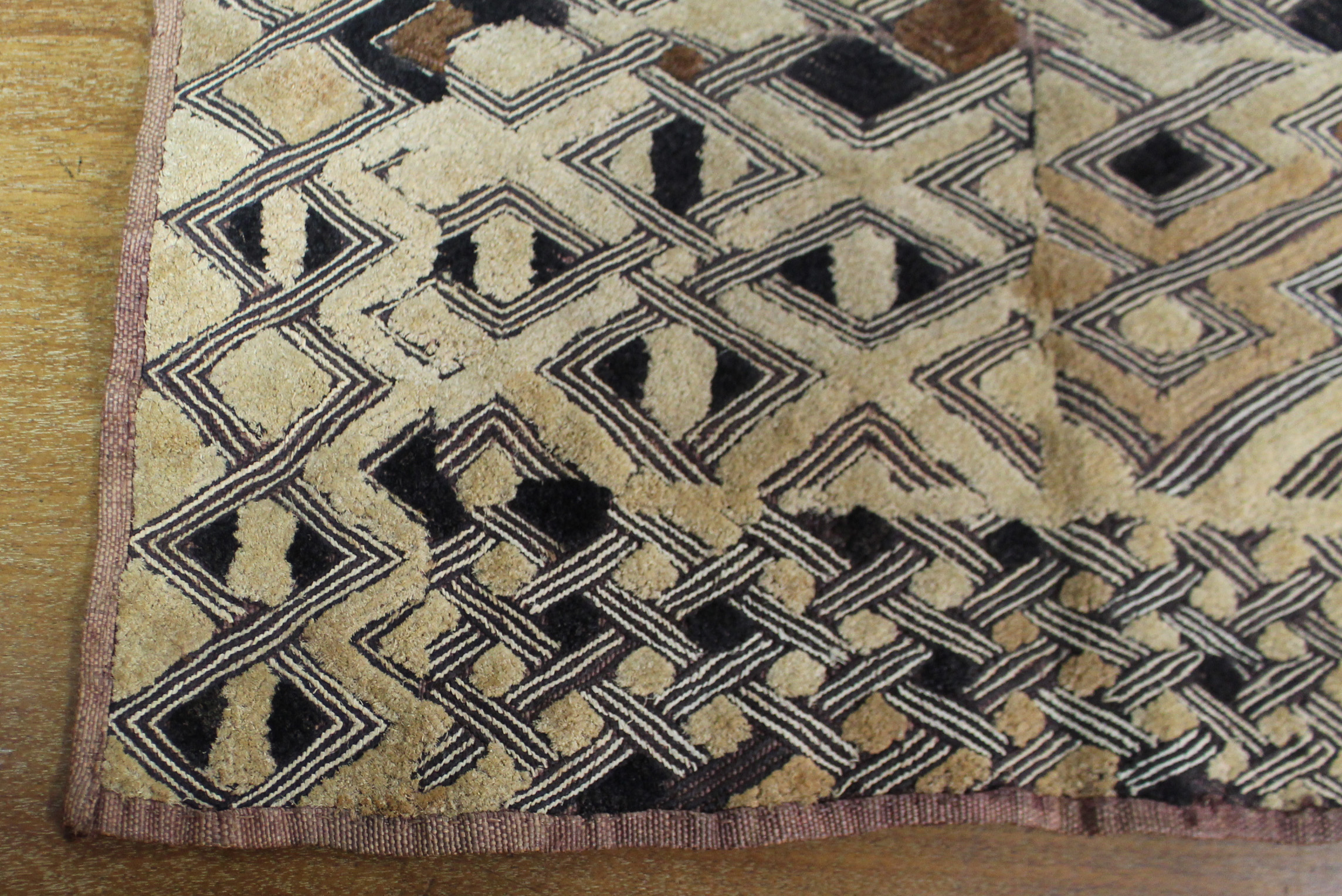 A Kuba cloth panel, the dark brown field with decorative trellis-pattern stitching & applied small - Image 5 of 7